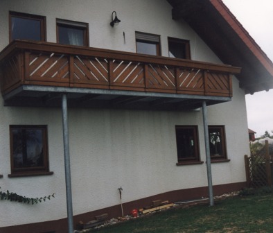 Geländer verzinkt an einem Außenbalkon, der Holzbalkon besitzt blickdichte schräge Holzleisten