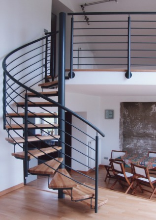 Spindeltreppe als Metalltreppe in Stahl mit einem gebogenen Treppengeländer
